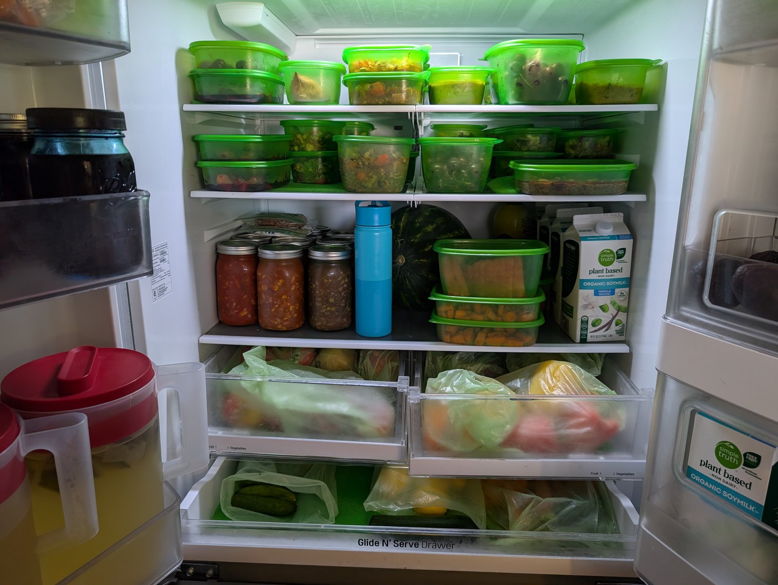 Open fridge with Debbie Meyer GreenBoxes for salad and mason jars of beans and spaghetti